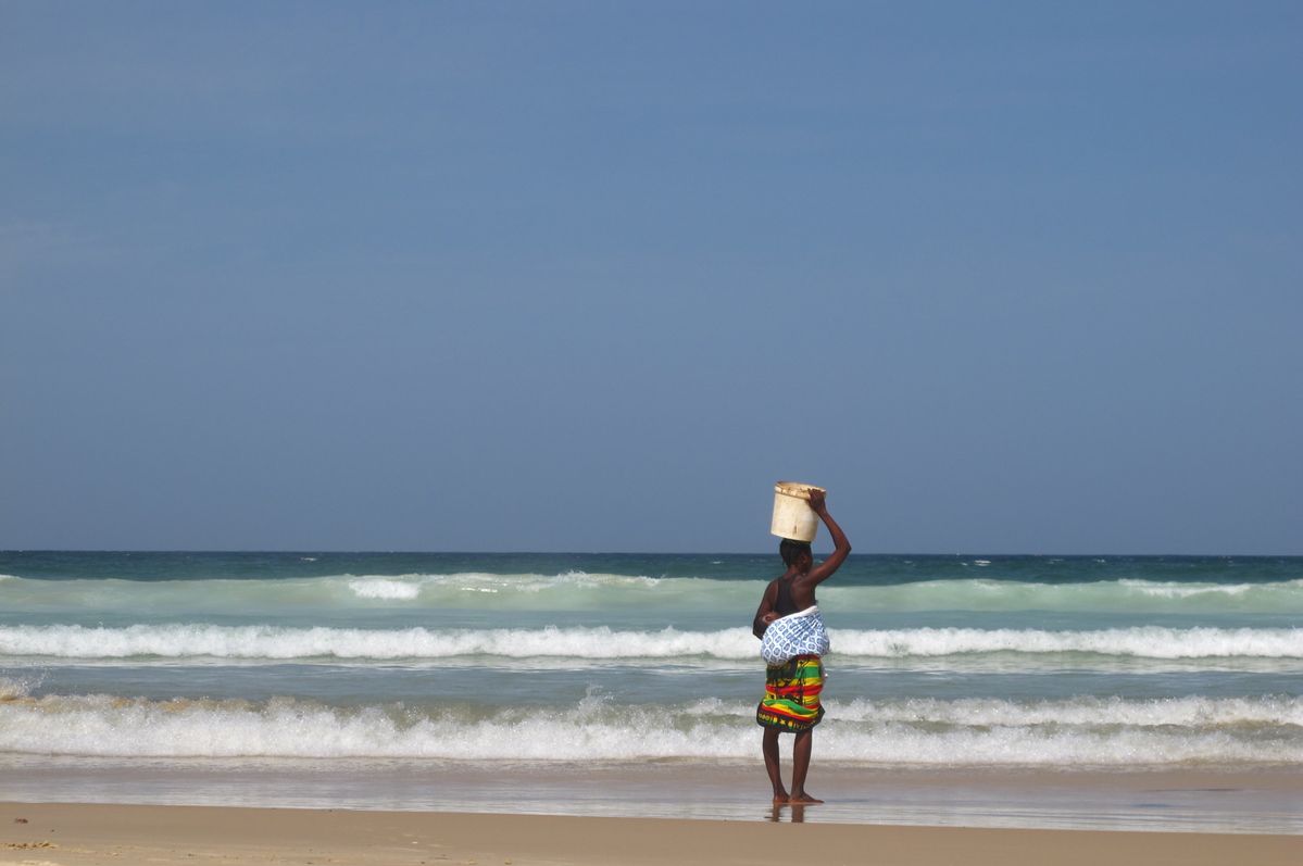 Woman with fish bucket on beach of Dakar, Senegal