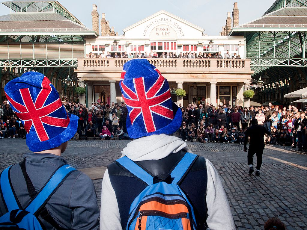 A street performer entertains tourists in Covent Garden